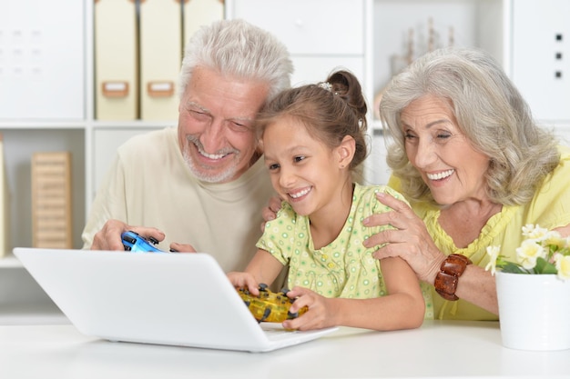 Nonni con sua nipote che usano il laptop insieme a casa