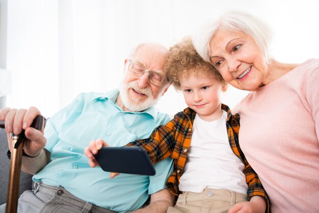 Nonni e nipote che giocano a casa - Famiglia a casa, nonna e nonno che si prendono cura del nipote