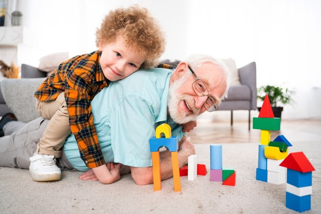 Nonni e nipote che giocano a casa - Famiglia a casa, nonno che si prende cura del nipote