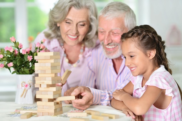 Nonni e nipoti seduti a tavola e che giocano con i blocchi di legno