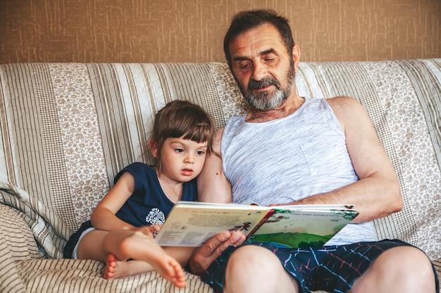 Nonno che legge un libro a sua nipote