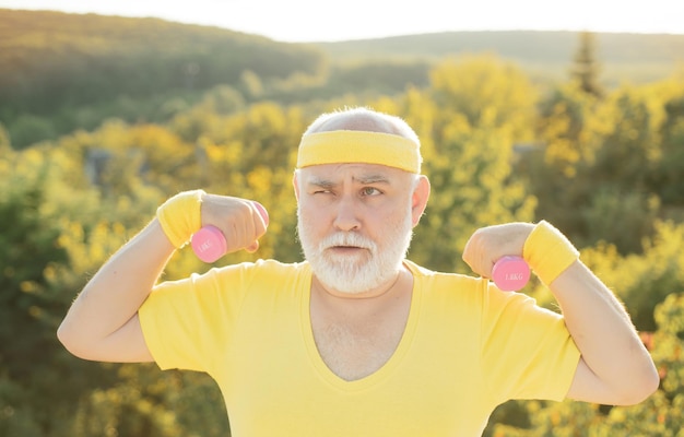 Nonno che si esercita con lo sport con manubri per uomo anziano uomo anziano nel parco che si allena con i pesi