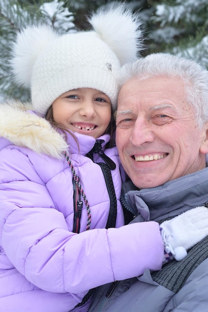 Nonno con nipote sorridente, in posa all'aperto in inverno