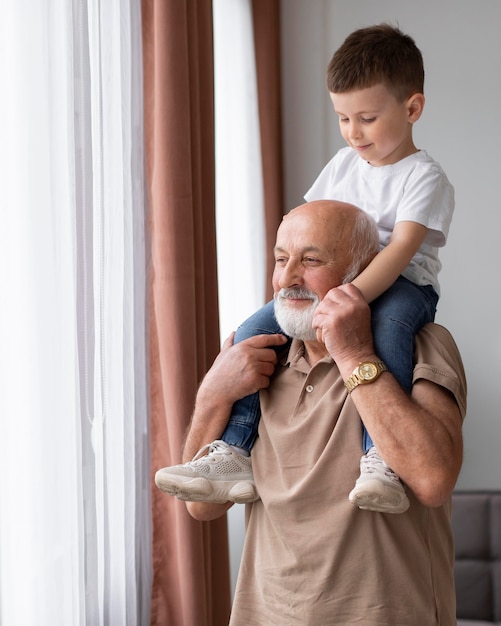 Nonno di tiro medio che tiene bambino