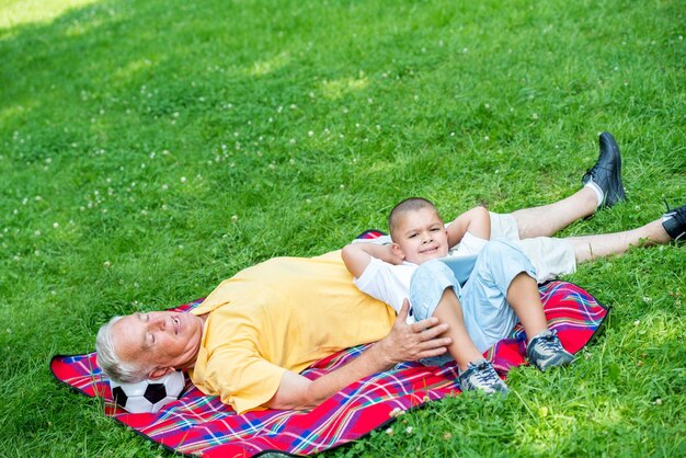 nonno e bambino utilizzando il computer tablet nel parco