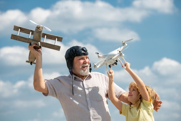 Nonno e figlio con drone aereo e quad elicottero sopra il cielo blu generazione di uomini nonno e nonno