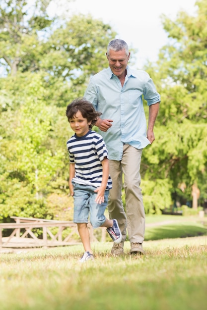 Nonno e figlio in esecuzione su erba nel parco