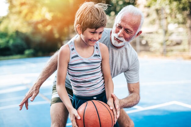 Nonno e nipote che giocano a basket.