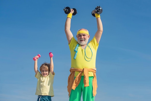 Nonno e nipote con manubri in mano Allenamento di fitness senior con manubri isolati