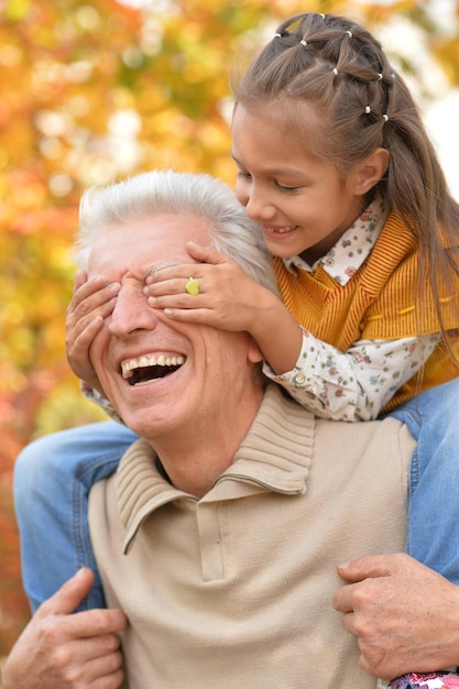 Nonno e nipote si divertono nel parco autunnale