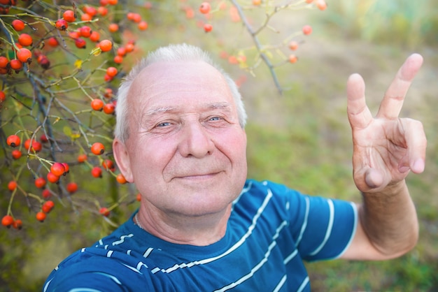 Nonno in pensione positivo, fa selfie foto con uno smartphone nel parco