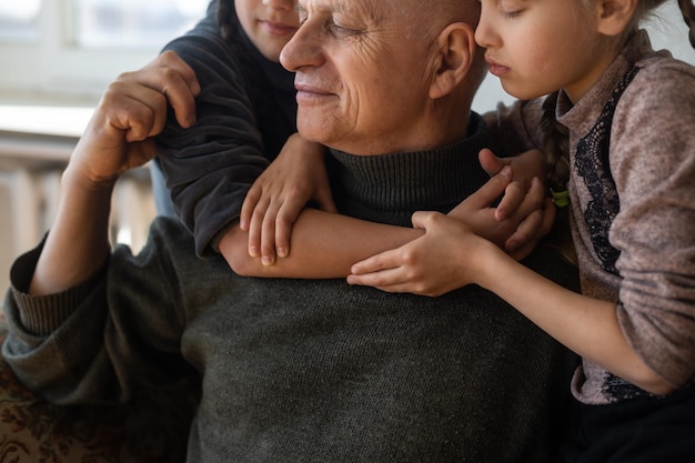 Nonno ucraino e due nipoti che si abbracciano