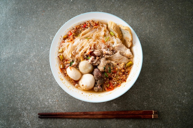 noodles con maiale e polpette in zuppa piccante o noodles Tom yum in stile asiatico