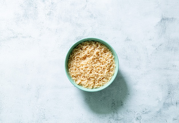 noodles istantaneiConcetto di mangiare gustoso con una ciotola di noodles su sfondo grigio