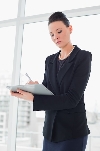 Note eleganti di scrittura della donna di affari in ufficio