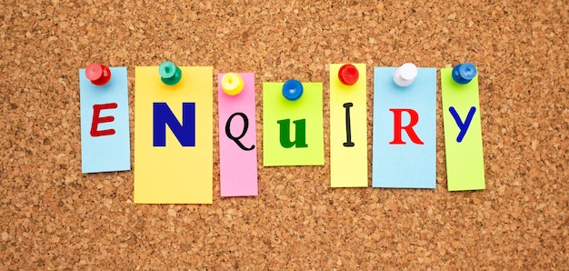 Note multicolori con lettere appuntate su una bacheca di sughero Word INQUIRY