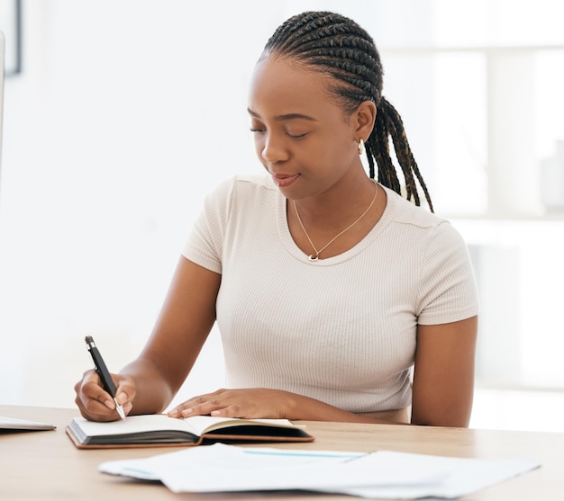 Notebook che lavora e donna di colore che scrive appunti in ufficio seduto alla scrivania Visione di idee e donna d'affari con la penna in mano per scrivere annotazioni e prendere appunti in riunioni di lavoro nel libro o nel diario di lavoro