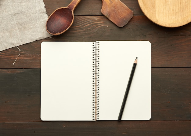 Notebook con fogli bianchi e utensili da cucina