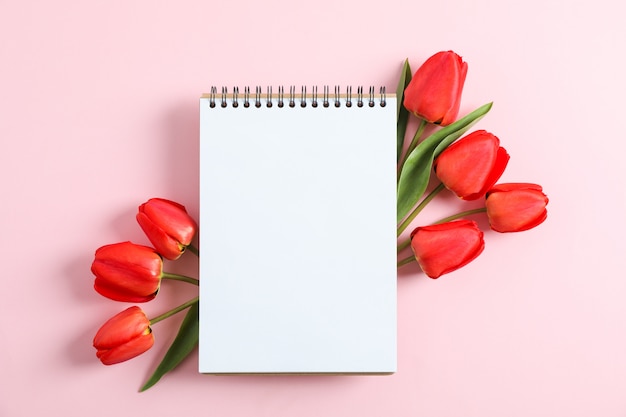 Notebook con spazio per il testo e bellissimi tulipani rossi sul colore