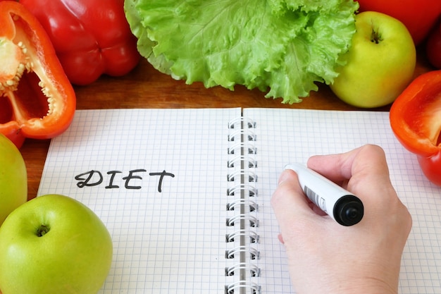 Notebook con un programma di dieta con verdure fresche, primo piano