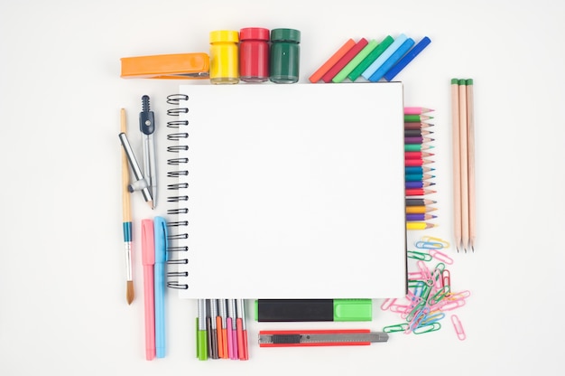 Notebook e strumenti di scuola o ufficio su sfondo bianco