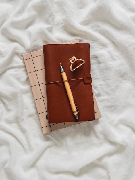 Notebook femminili in stile minimalista penna per clip per capelli su uno sfondo chiaro vista superiore