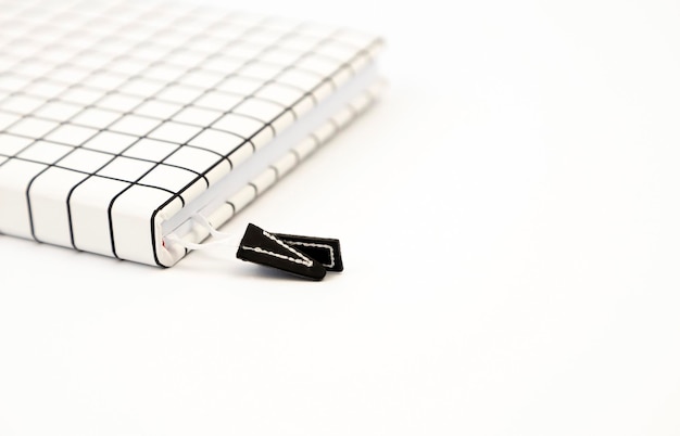 Notebook in una cella bianca su sfondo bianco Posto per il testo