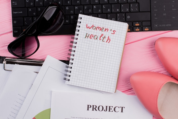 Notebook per le cose da donna sul desktop dell'ufficio