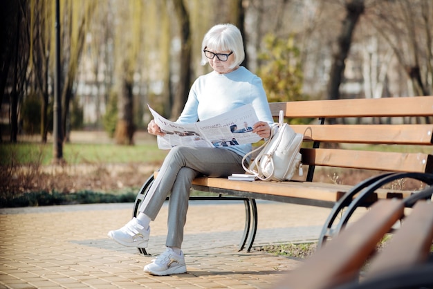 Notizia importante. Grave donna invecchiata leggendo un giornale mentre è seduto sulla panchina