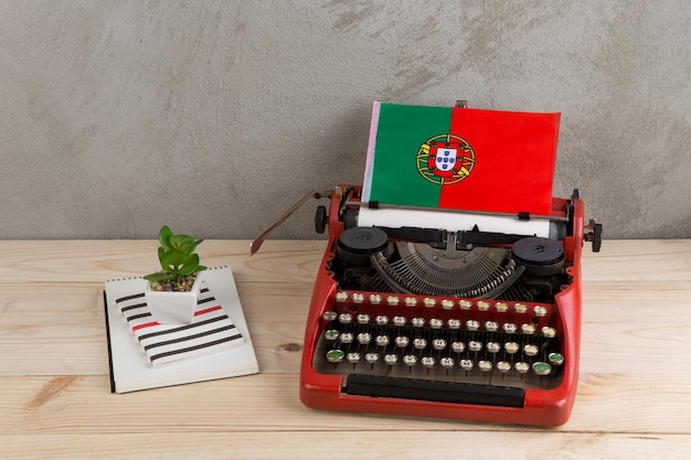 Notizie politiche e concetto di istruzione bandiera rossa della macchina da scrivere vintage dei blocchetti per appunti a matita del Portogallo