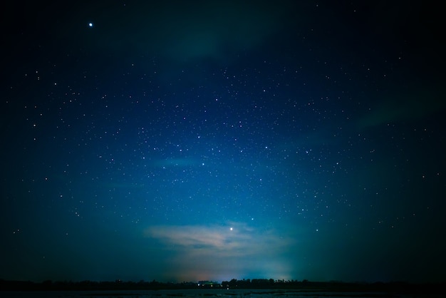 Notte blu e scura con molte stelle brillanti sul lago