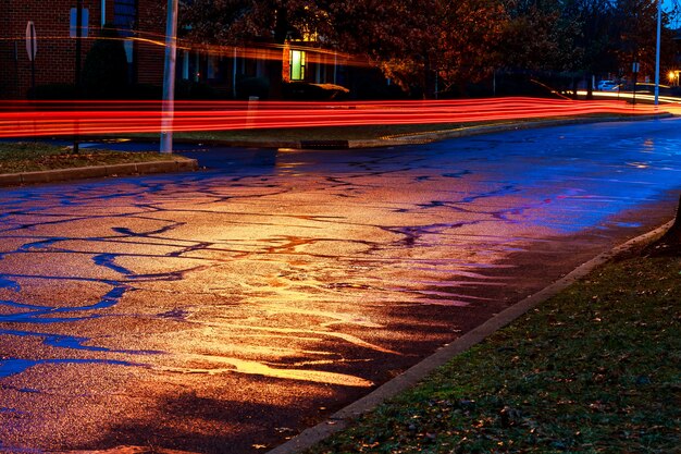 Notte di pioggia nella grande città, luce dalle vetrine dei negozi riflesse sulla strada