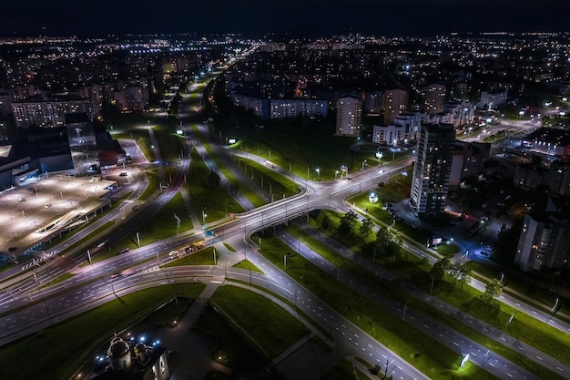 Notte su strada di intersezione di incrocio stradale con auto con fari in autostrada vita notturna nella grande città che guarda verso il basso sul traffico