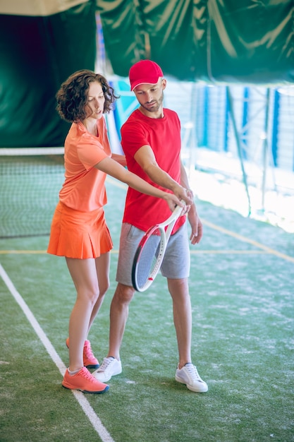 Novizio. Allenatore di tennis femminile che spiega al principiante le regole del gioco del tennis