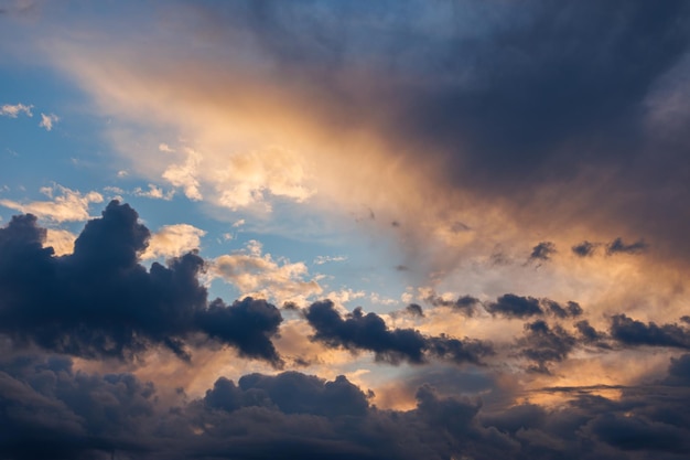 Nubi cumuliformi sul cielo serale retroilluminato con il tramonto