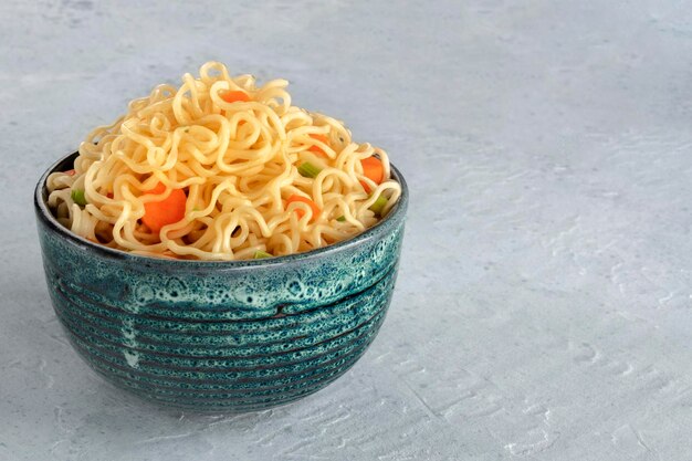 Nudle istantanee con carota e cipolle, ciotola di soba vegetale con spazio per le copie