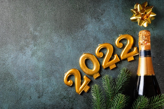 Numeri 2022 con bottiglia di champagne e decorazioni. Felice anno nuovo e concetto festivo. Copyspace di vista orizzontale superiore. Anno nuovo piatto. Piatto di Natale. Nuovo anno 2022. Concetto di nuovo anno.