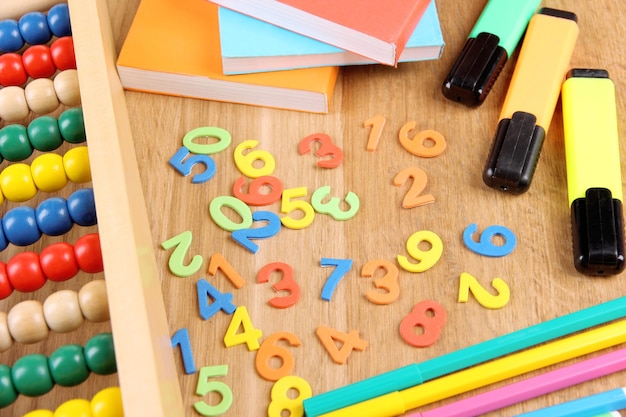 Numeri colorati abacus libri e marcatori su sfondo di legno