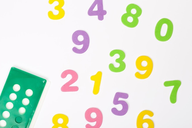 Numeri in schiuma dai colori vivaci e strumento di conteggio. Sfondo