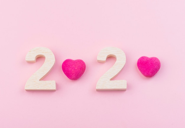 Numero di legno del 2020 con cuore rosa su sfondo rosa