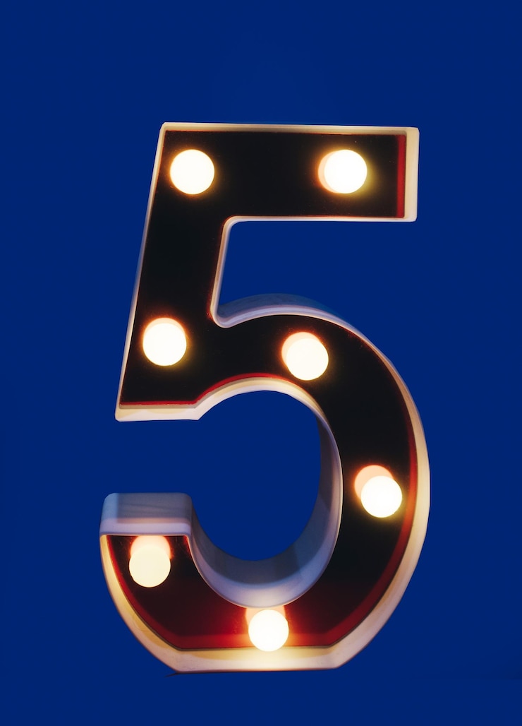 Foto numero illuminato cinque 5 con lampadine isolate
