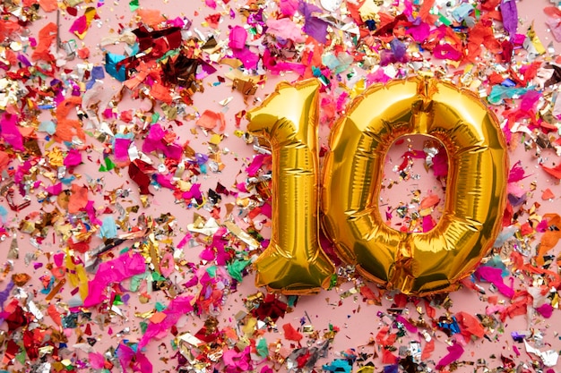 Numero oro compleanno celebrazione palloncino su uno sfondo di coriandoli glitter