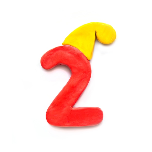 Numero rosso di plastilina due in cappello invernale giallo su sfondo bianco