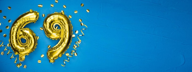 numero sessantanove palloncino di folio giallo dorato su sfondo di cemento blu biglietto di compleanno o anniversario con l'iscrizione 69 Celebrazione dell'anniversario