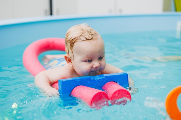 Nuotare in piscina dalla nascita Il ragazzo ha imparato a nuotare in acqua Fortunato bambino con allenatore in piscina giocando e divertendosi Una famiglia sana e sportiva con un bambino