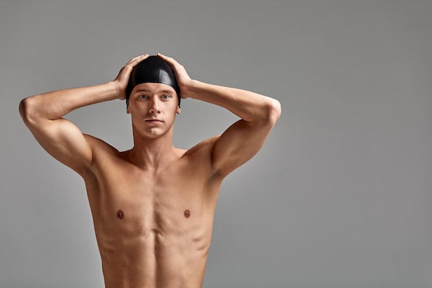 Nuotatore con un berretto su sfondo grigio che si prepara a nuotare banner pubblicitario in primo piano per lo spazio della copia delle piscine