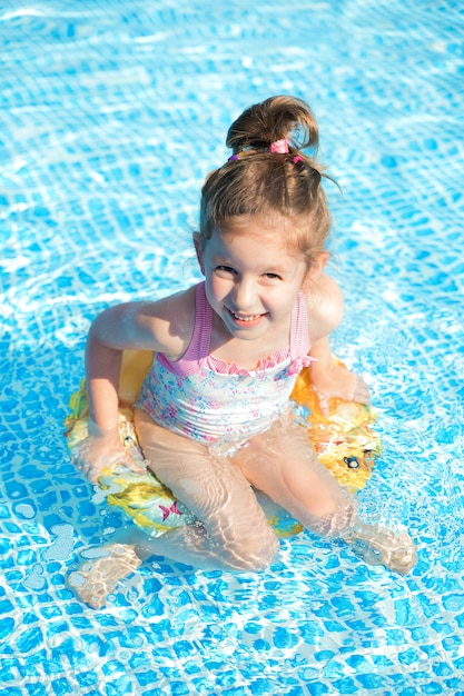 Nuoto divertente della bambina nello stagno