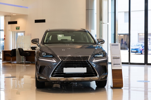 Nuova auto grigia nel moderno showroom del concessionario