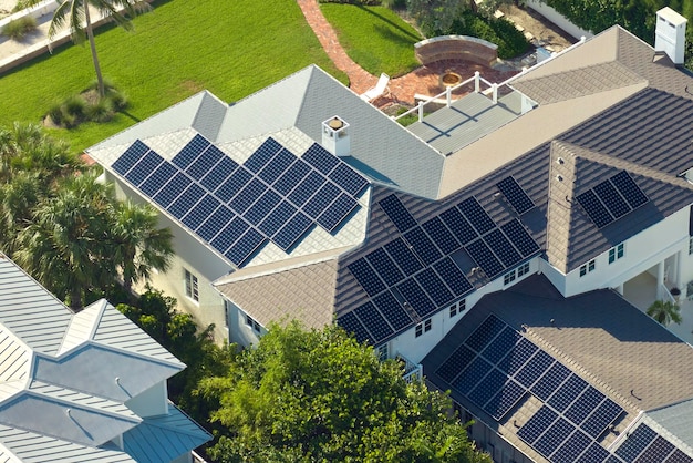Nuova casa residenziale negli Stati Uniti con tetto ricoperto di pannelli solari per la produzione di elettricità ecologica pulita in un'area rurale suburbana Concetto di investimento in una casa autonoma per il risparmio energetico