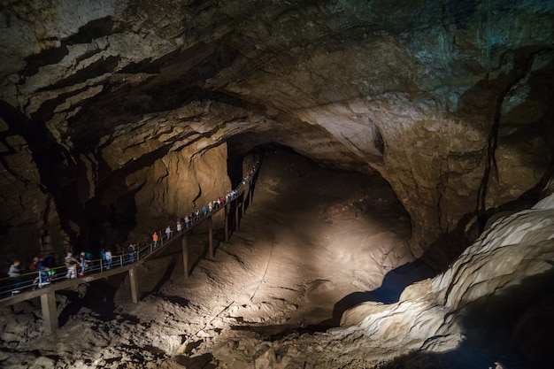 Nuova caverna di Athos, Abkhazia. La gente cammina lungo il ponte all'interno della grotta